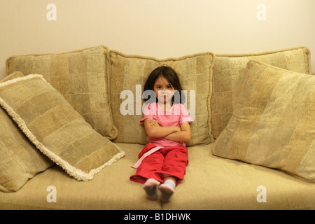 Vier Jahre altes Mädchen auf großes Sofa sitzt Stockfoto