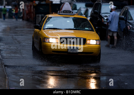 Ein New York City Taxi fährt hinunter einen Regen durchnässt Straße in Manhattan, New York. Stockfoto