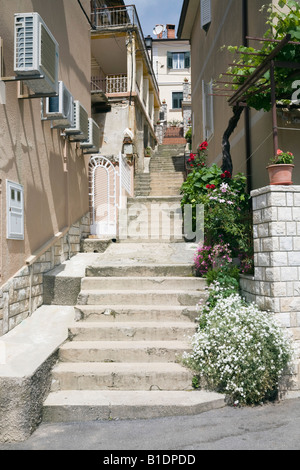 Moscenicka Draga-Istrien-Kroatien-Stein tritt in engen Gasse zwischen alten Gebäuden mit Klimaanlagen auf Wand Stockfoto