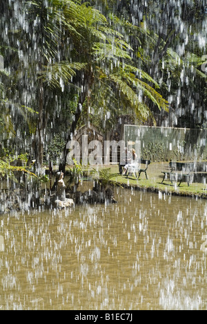dh Monte Palace Tropical Garden MONTE MADEIRA Wasserfall Wasser und Touristen auf der Bank entspannende Teichgärten Stockfoto