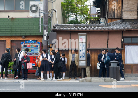 Kyoto, Japan. Die Schüler der Sekundarstufe warten in ihrer Schuluniform an einer Bushaltestelle Stockfoto