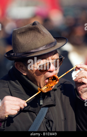China Peking chinesische neue Jahr Frühling Festival Changdian street fair ein älterer Mann Essen Schaschlik Stockfoto