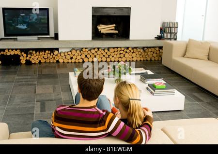 Rückansicht eines jungen Paares auf einer Couch sitzen und Fernsehen Stockfoto
