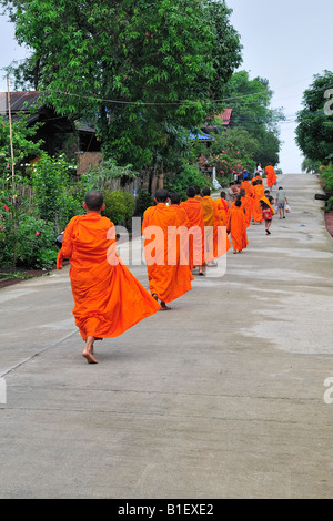 Buddhistische Mönche und Novizen zu Fuß zurück zum Tempel, nachdem sie sich ihre Nahrung am Morgen Stockfoto