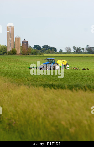 Ein Traktor Dünger auf einem späten Frühjahr Feld im ländlichen Illinois zu verbreiten. Stockfoto