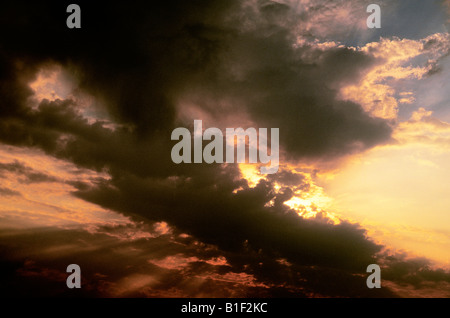 Gewitterwolken. Hitzewelle oder Hitzewelle dramatischer Himmel Sonnenuntergang oder Sonnenaufgang. Dunkle schwarze Wolken bedecken untergehende oder aufgehende Sonne. Wetterwechsel und bewölkter Himmel Stockfoto