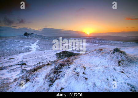 Winterlichen Sonnenaufgang auf Dartmoor National Park mit einer Übernachtung Schneefall in tadellosem Zustand wie die Morgenröte bricht über Heu Tor Stockfoto