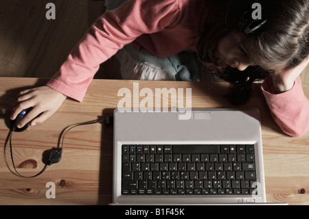 Schulmädchen 6 Jahre alt auf Computer im Haus Stockfoto