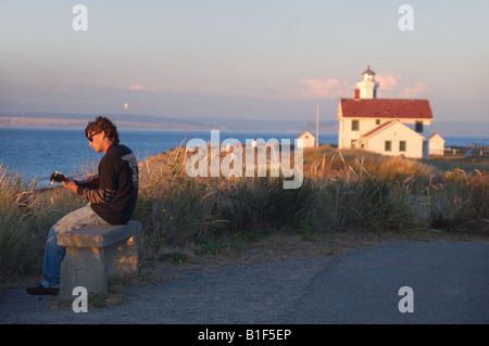 junger Mann, die Gitarre am Punkt-Wilson Leuchtturm bei Sonnenuntergang Stockfoto