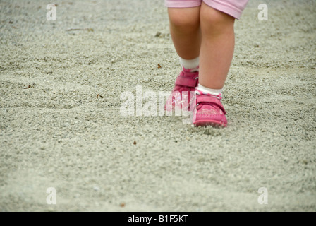 Stock Foto von den Beinen ein zwei Jahre altes Mädchen in den Kies auf dem Spielplatz spielen Stockfoto