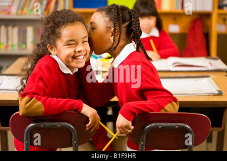 Afrikanische Mädchen erzählen Geheimnis im Klassenzimmer Stockfoto