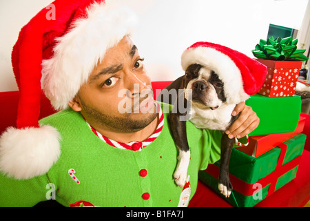 Afrikanischer Mann und Hund trägt der Weihnachtsmann-Mützen