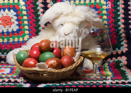 Osterhase mit bunten Eiern in den Korb und das Glas sein Lieblingsgetränk Stockfoto