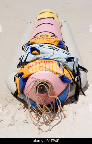 Ein Bananenboot steht auf einem thailändischen Strand mit Schwimmwesten drauf. Stockfoto