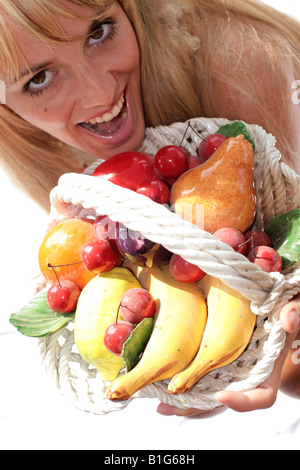 Draufsicht auf eine Frau lächelt und hält Obstkorb Stockfoto