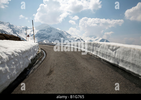 Gereinigte Straße in den schweizer alpen mit Schnee auf der Kanten der Straße Stockfoto