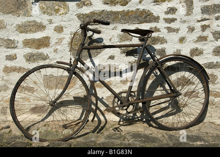 Stock Foto von einem alten Fahrrad gelehnt eine Steinmauer aufgeschlüsselt Stockfoto