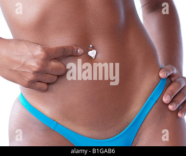 Eine Frau zeigt Bauchnabel-piercing Stockfoto