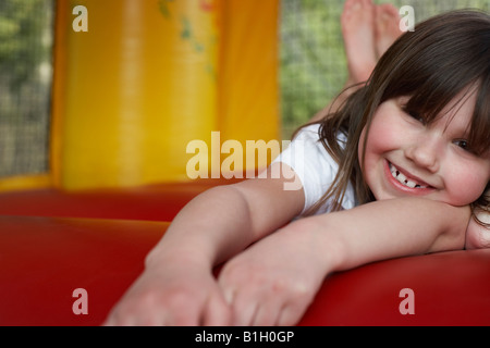 Mädchen (7-9) in Hüpfburg, Porträt, nah oben liegend Stockfoto