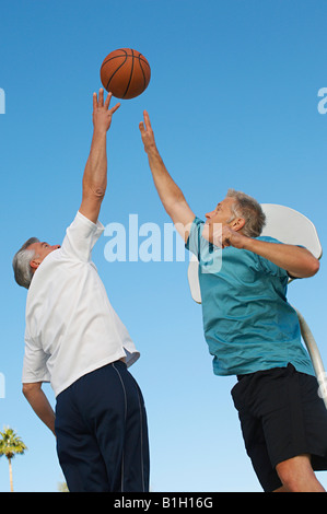 Alte Männer spielen Basketball auf Freiplatz Stockfoto
