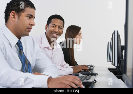 Drei Geschäftsleute, die mit dem Computer im Büro Stockfoto Drei Geschäftsleute, die mit dem Computer im Büro Stockfoto