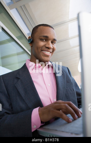 Mitte erwachsener Mann mit Laptop im Freien, portrait Stockfoto