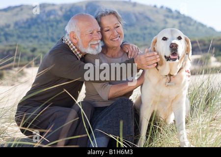 Älteres paar streicheln eines Hundes Stockfoto