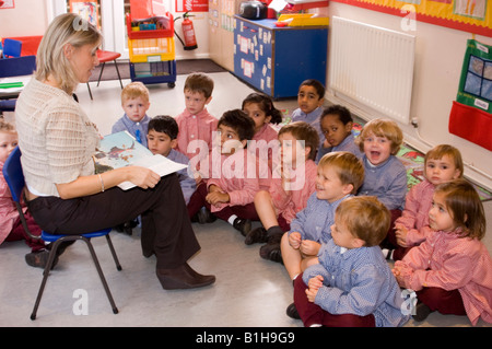 Lehrer für Kindergarten-Kinder lesen Stockfoto