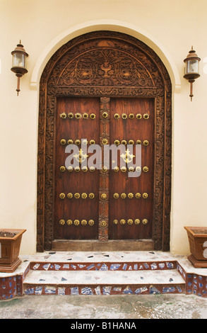 Tür mit Details von Messing verziert und Schnitzen in Stonetown, Sansibar, Tansania, Ostafrika. Stockfoto