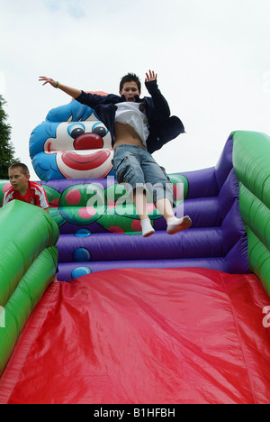 Junge springt auf aufblasbaren Rutsche bei einem Kinderfest Stockfoto