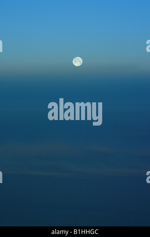 Der Mond von Höhe über dunstig und Verdunkelung Cloud gegen einen hellblauen Himmel aus gesehen Stockfoto