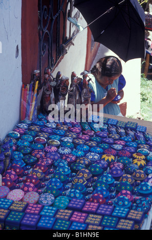 Indigene Frau malt eine Holzkiste auf dem Kunsthandwerk-Markt, Taxco, Mexiko Stockfoto