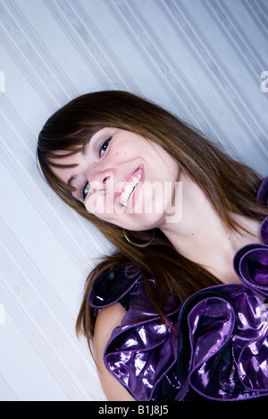 junge Frau mit langen, dunklen Haaren und violetten Halskrause, lachen Stockfoto