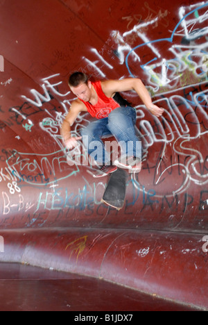 männlichen Teenager mit seinem Skateboard springen Stockfoto