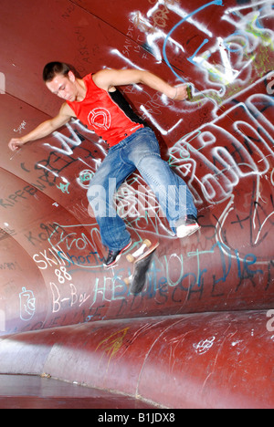 männlichen Teenager mit seinem Skateboard springen Stockfoto