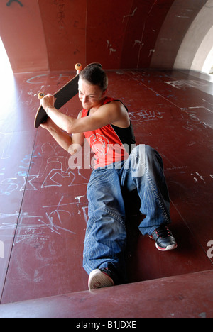 wütend männlichen Teenager sitzen auf einem Skater-Kurs Stockfoto