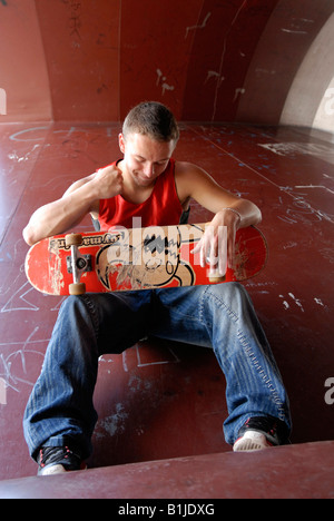 wütend männlichen Teenager sitzen auf einem Skater-Kurs Stockfoto