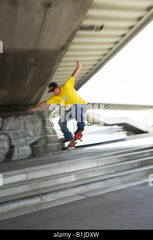 männlichen Teenager im Erdgeschoss mit seinem Skateboard springen Stockfoto