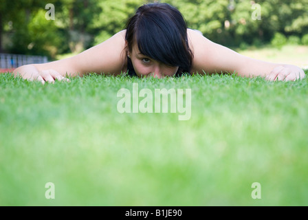 junge Frau mit Sport Kleid auf einer Wiese erschöpft liegend Stockfoto