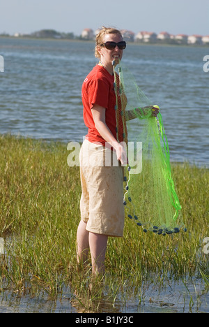 Kajakfahrer lernen, eine Besetzung netto um Fische zu fangen entlang der Seite der Bucht von St. George Island entlang North Florida s Pfannenstiel zu werfen Stockfoto