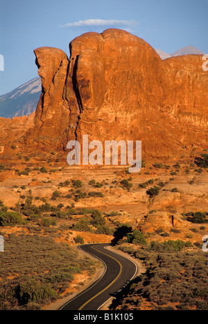 Blacktop Serpentinenstraße durch Wüste mit Felsformationen aus Sandstein in den Hintergrund Arches National Park in Utah Stockfoto