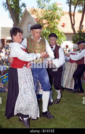 Älteres Ehepaar durchführen Volkstanz in traditioneller Kleidung während der Feier des schwedischen Nationalfeiertag Stockfoto