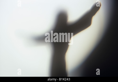 Impressionistische Jesus Christus-Figur mit Arme ausgestreckt und Silhouette gegen eine Welle oder ein Kreis von hellem Licht Stockfoto