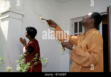 Bruder und Schwester konfrontiert Ost und beten direkt zu Surya Sonnengott während das hinduistische Erntefest Pongal in Indien Stockfoto