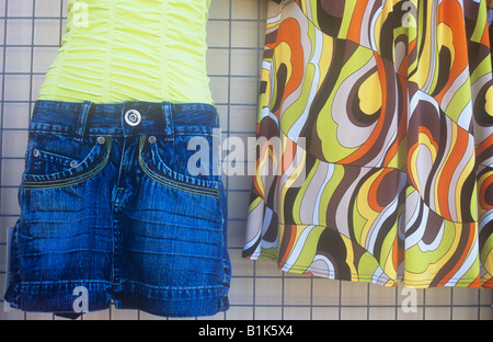Detail der ziemlich billig aussehende Damen Kleidung auf dem Display vor Geschäft mit Denim shorts Crimplene Top und Retro-1970er Jahre Psychedeli Stockfoto