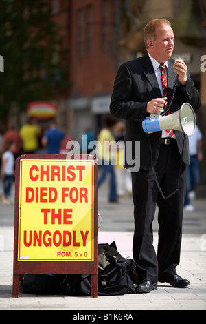 männlichen christlichen fundamentalistischen Prediger mit Lautsprecher und Bibel Vers auf Schild an sonnigen Nachmittag im wichtigsten shopping Bereich belfast Stockfoto