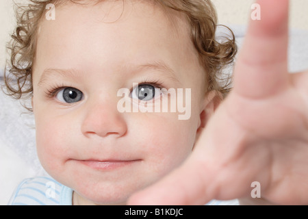 Porträt freche kleine Baby, die Hand auszustrecken, um zu greifen Stockfoto