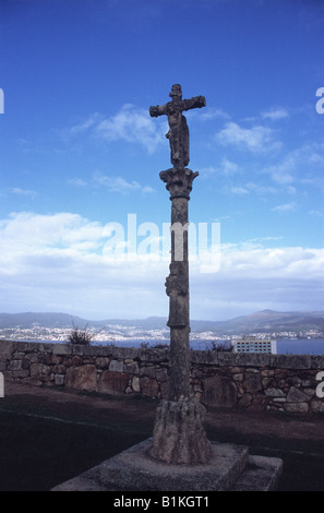 Traditionelles steinkalvarienkreuz namens Crucero/cruceiro in Castillo de San Sebastian, Hafen und Ria de Vigo in der Ferne, Vigo, Galicien, Spanien Stockfoto