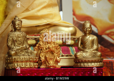 Zwei Statuen von Buddha Gautama (Sakyamuni) (links, rechts) und Maitreya (zukünftige Buddha) Figur in traditionellen tibetischen Gebetsraum Stockfoto