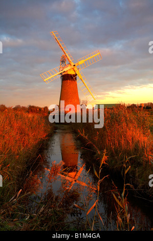 St Benets Windmill kurz vor einem dramatischen Sonnenuntergang auf den Norfolk Broads National Park, UK. Stockfoto